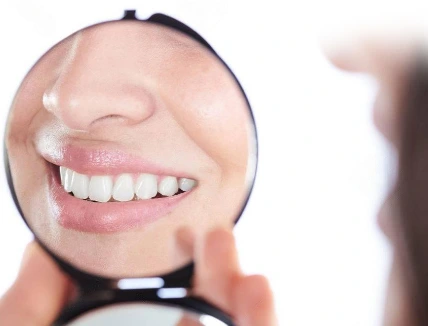 Patient admiring a bright, natural-looking smile after dental treatment at Paradise Dentistry Cabo.